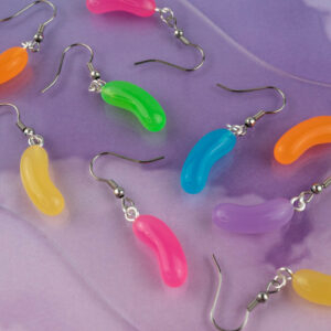 Jellybean earrings in a mix of bright colours! Includes Green, pink, blue, and orange. They're against a purple cloudy background and a logo in the bottom right says Candy Goblins