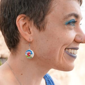 A person grins while wearing a Laughing Cow earring