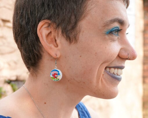 A person grins while wearing a Laughing Cow earring