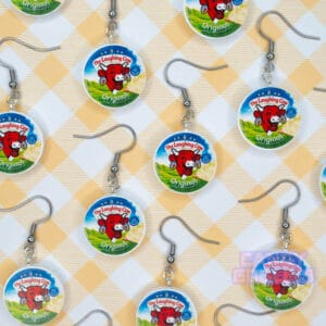 Many Laughing Cow earrings on a yellow background