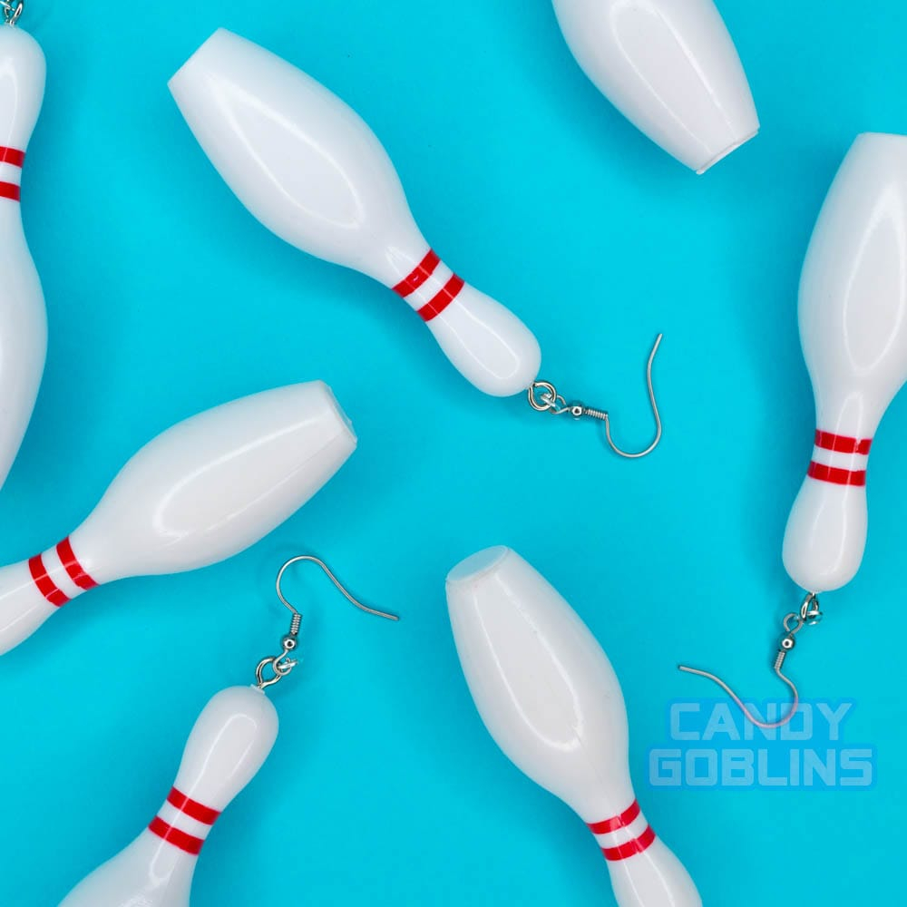Bowling pin earrings are scattered over a blue background