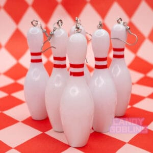 Several bowling pin earrings are lined up, like pins would be at a bowling alley
