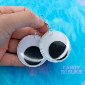 Someone holds a pair of our googly eye earrings.