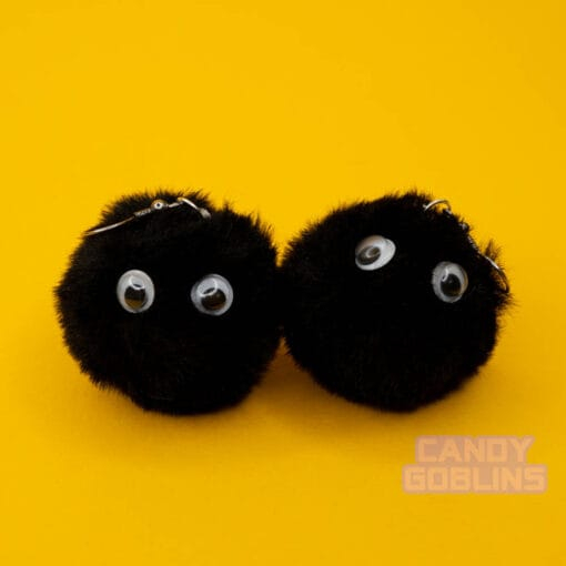 A pair of soot sprite earrings stare with googly eyes in their black fur