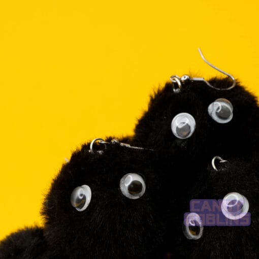 Black soot sprite earrings are stacked up in a big pile. The googly eyes on the sprites stand out like they're looking at you.