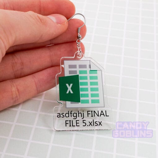 A single Excel Earring is held against a green backdrop. The earring features the Microsoft Excel logo, with text underneath that reads "asdfghj FINAL FILE 5.xlsx"