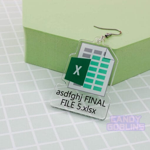 A single Excel Earring leans against a green prop. The earring features the Microsoft Excel logo, with text underneath that reads "asdfghj FINAL FILE 5.xlsx"