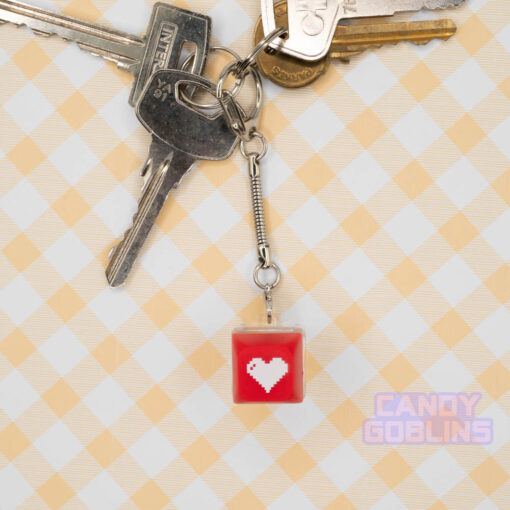 A red Keyboard Switch Keychain with a white heart