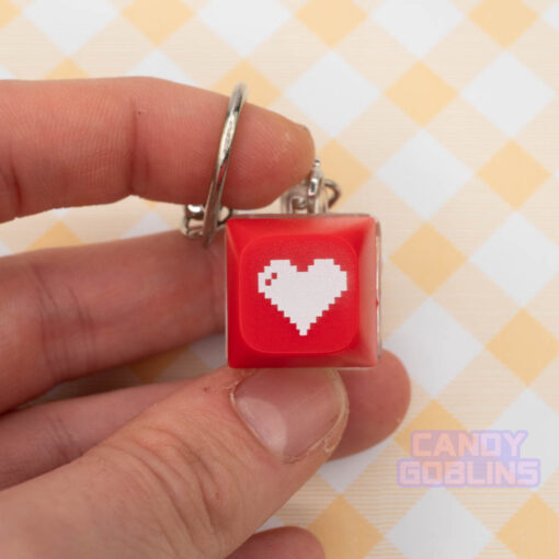 A red Keyboard Switch Keychain with a white heart