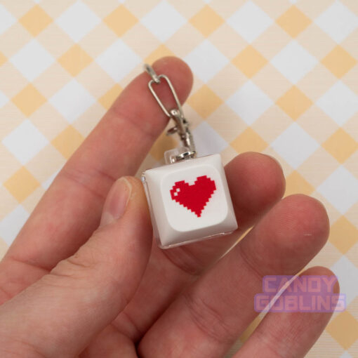 A white Keyboard Switch Keychain with a red heart