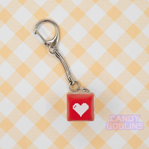 A red Keyboard Switch Keychain with a white heart