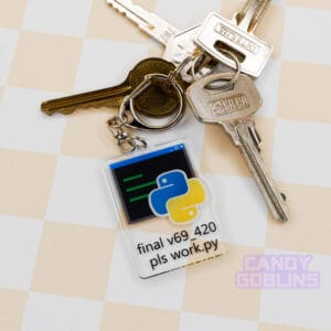 Our Python keychain is attached to a set of keys that is laid out against a pastel yellow backdrop. The keychain features the Python logo, with text underneath that reads "final v69_420 pls work.py".