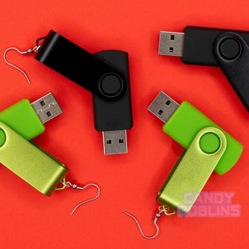 USB stick earrings scattered across a red background. Some of them are black, and others are bright green.