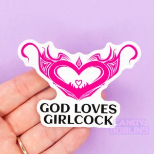 A person holds a sticker that reads God Loves Girlcock, and above is a hentai womb tattoo design.
