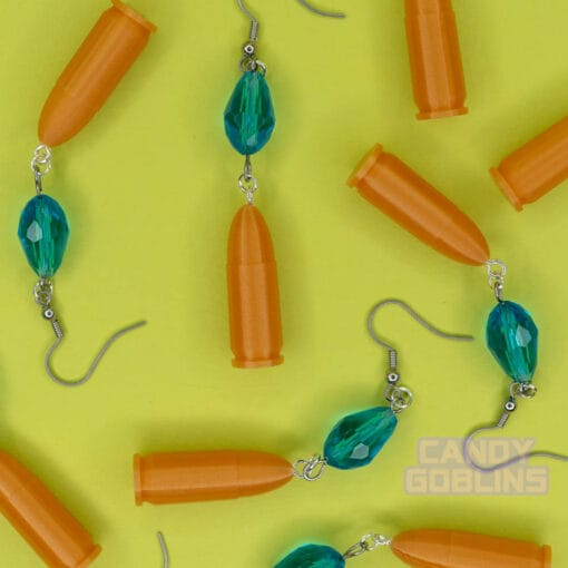 Our Revolver Earrings are scattered across a photo backdrop
