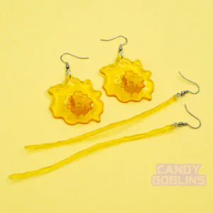 Our piss earrings are against a yellow background. One pair is a stream, the other is a splash.