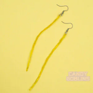 A pair of piss earrings against a yellow background. The urine is in a long stream.