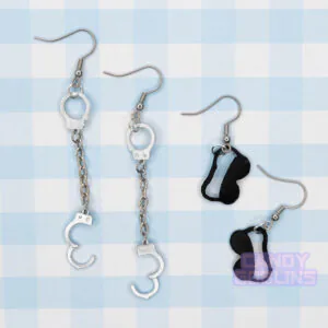 Handcuff and eye mask earrings sit next to each other