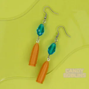 A pair of our Revolver Earrings lie against a photo prop